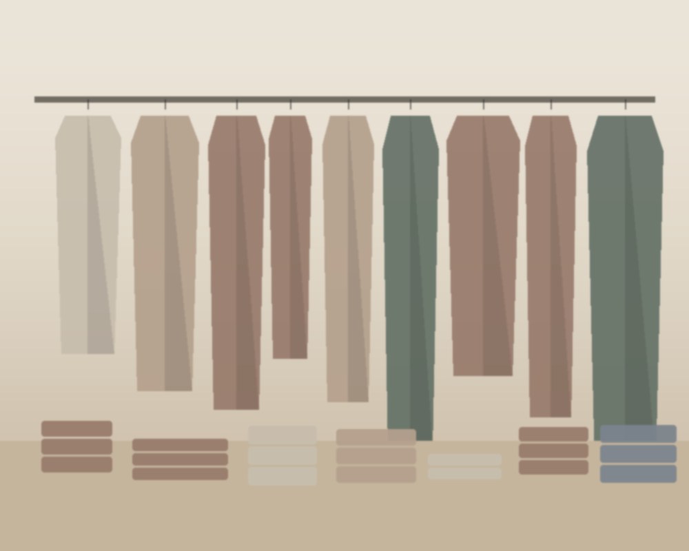 Detalhe de peças de roupa dobradas e acessórios sobre bancada de loja